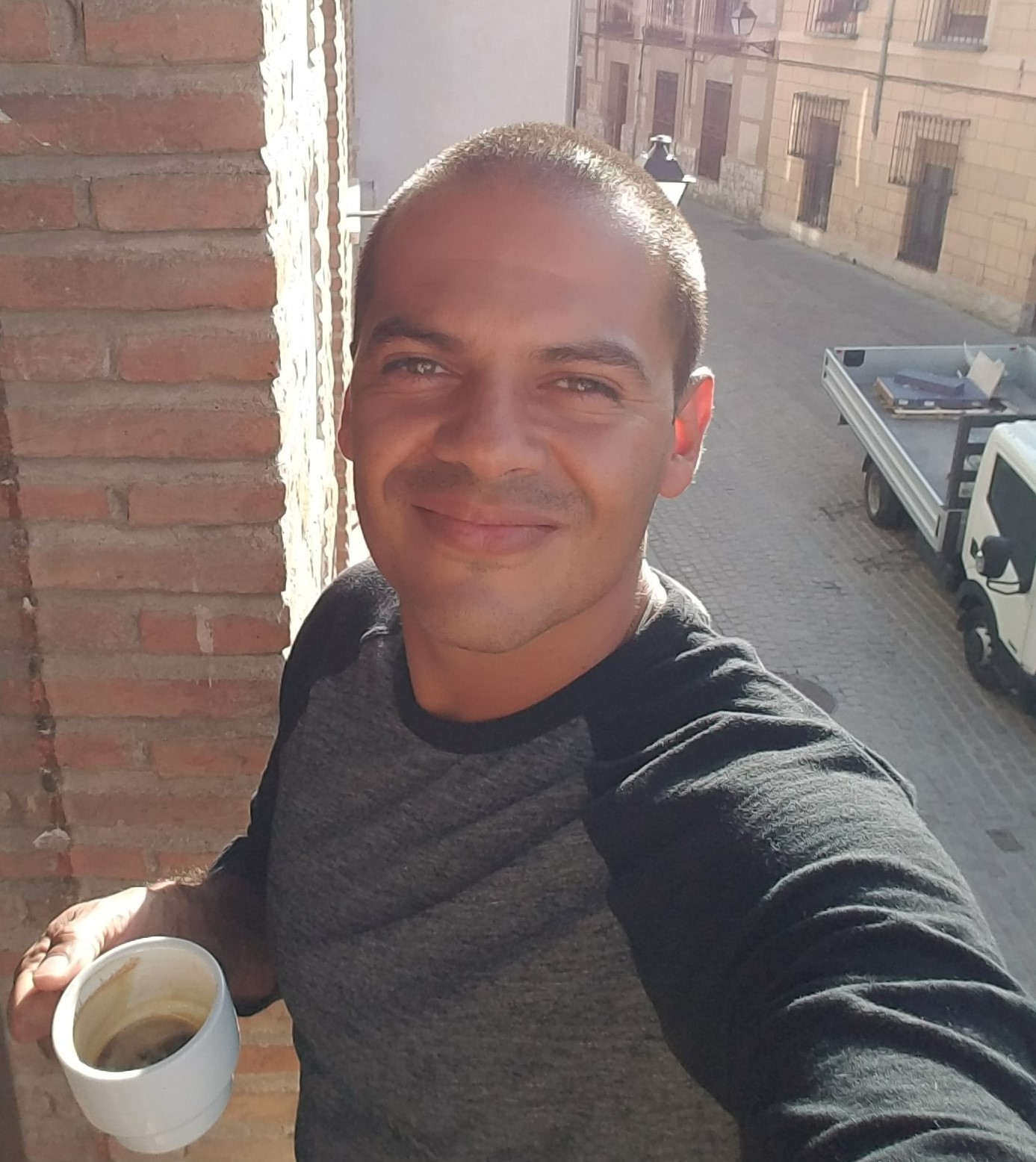 Photo of Carlos Solorzano, Staff Accountant at GBLS. Carlos is smiling at the camera and holding a cup of coffee.