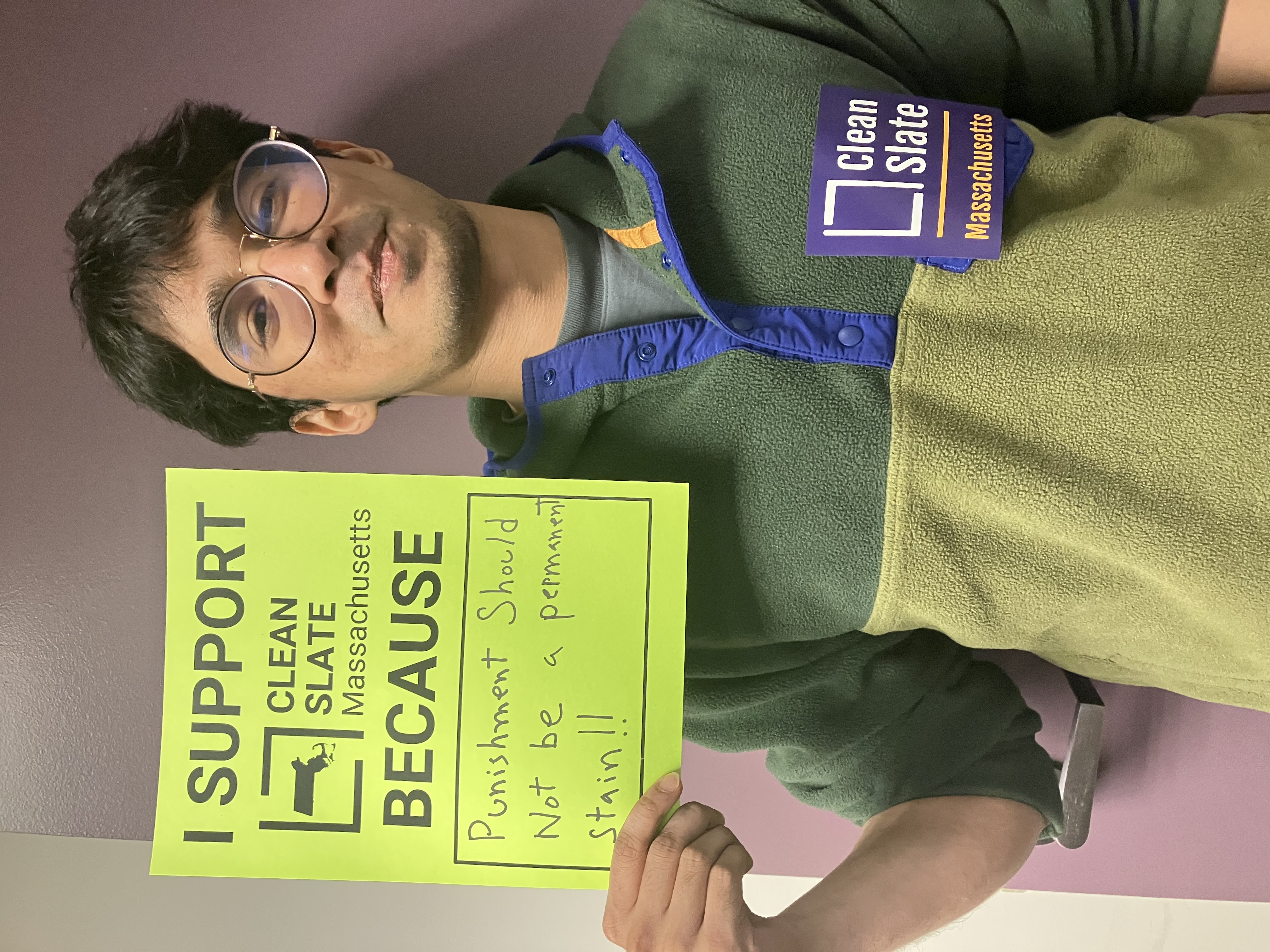 A GBLS staff member holds a sign supporting Clean Slate legislation