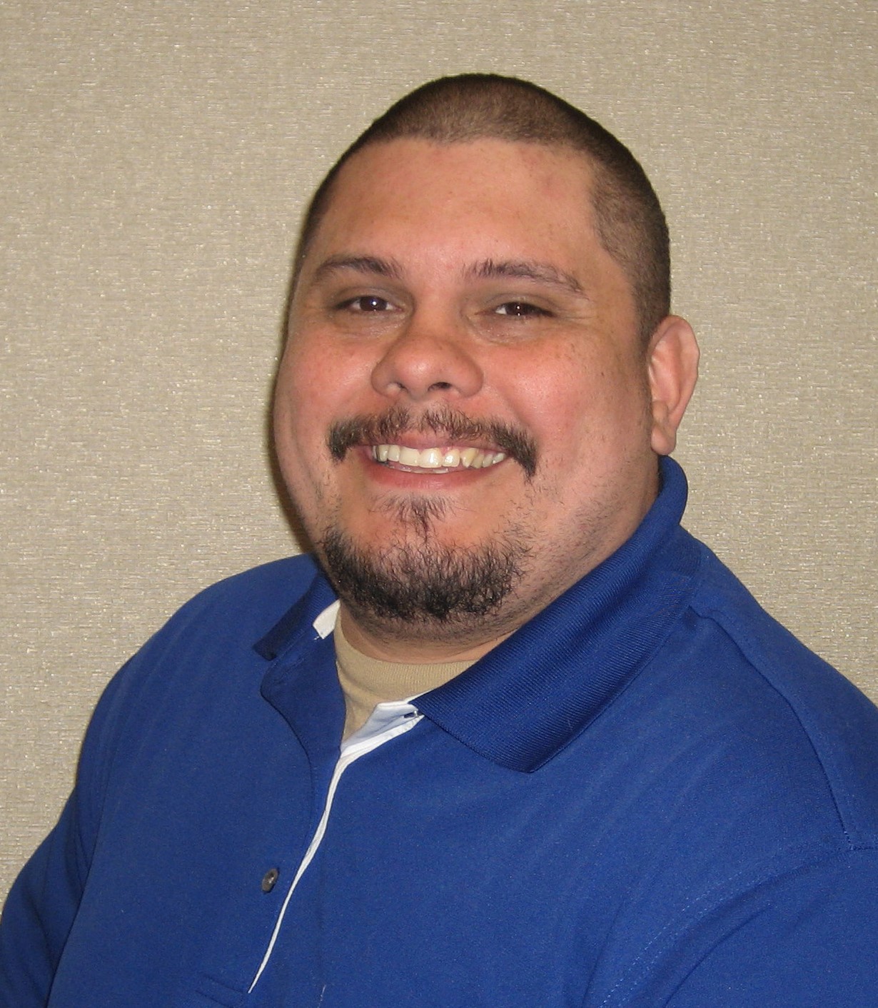 Photograph of Juan Valdes, he is smiling and wearing a blue shirt.