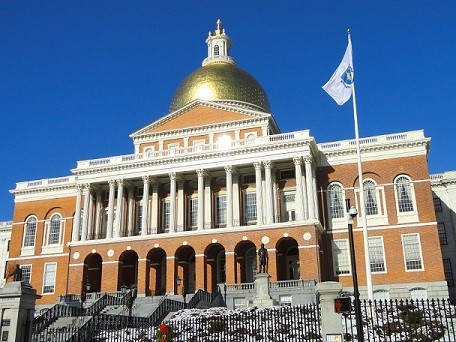 Sunlight photo of the Massachusetts State House with the sunlight gleaming off of its golden dome.