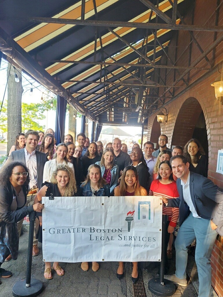 Photo of a group of people holding a GBLS sign at the Associate's Fund Drive event