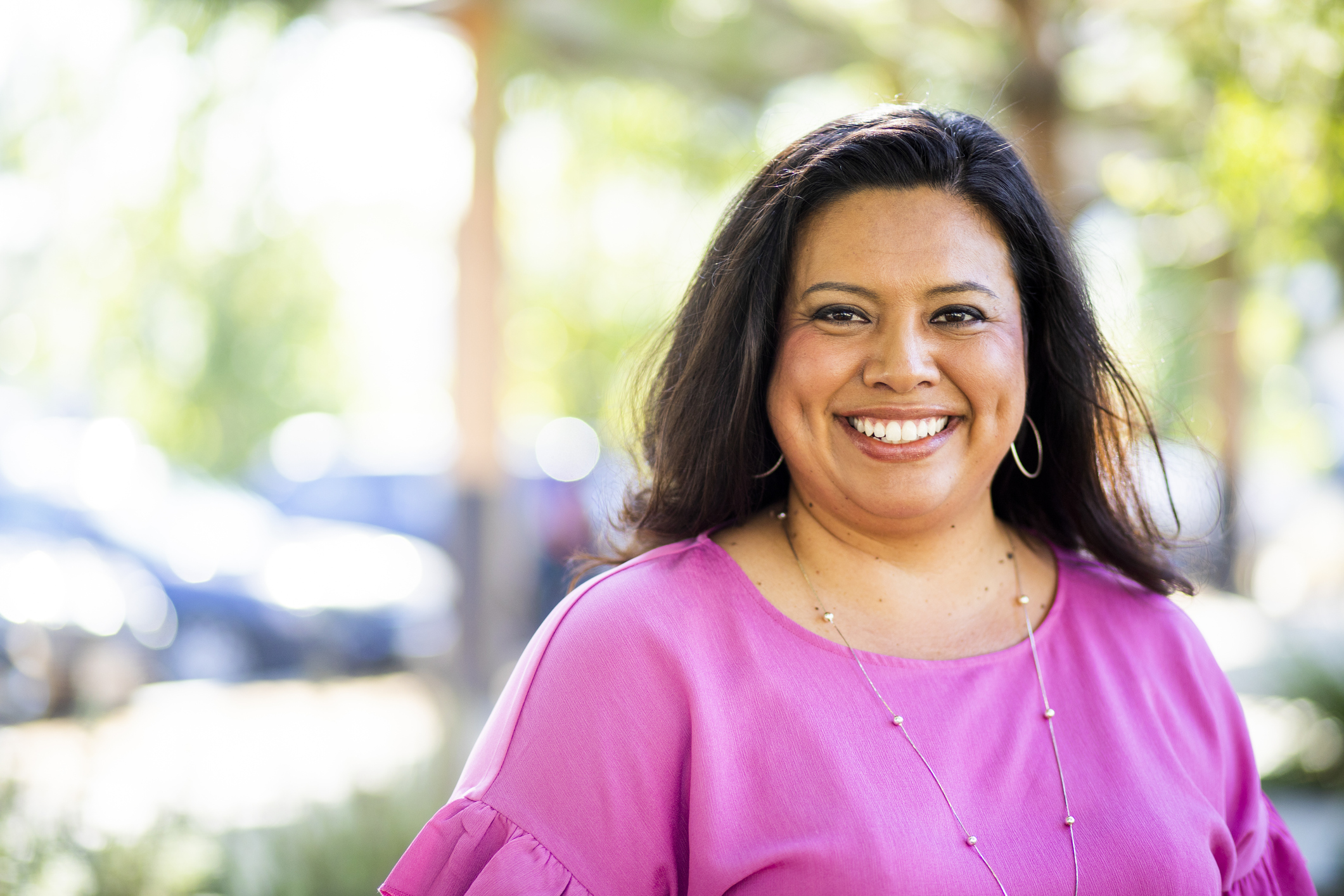 Photo of a smiling woman in a pink shirt