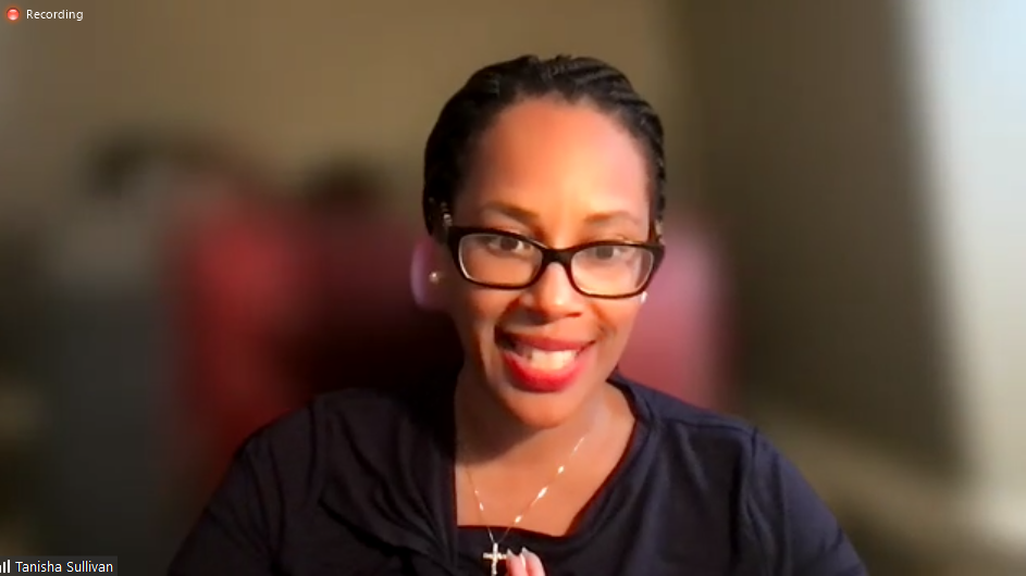 Photo of Tanisha Sullivan, who is wearing a black blouse, black glasses, and red lipstick 