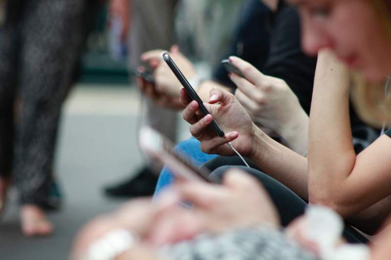 Person using smart phone (Photo by ROBIN WORRALL on Unsplash)