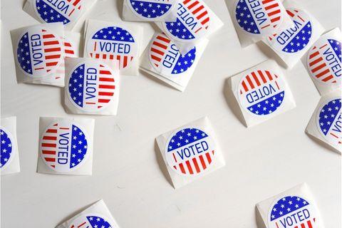 Scattered red and blue Voted stickers on white table