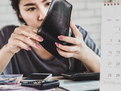 stressed asian woman open empty wallet looking for money for debt with bills stock photo