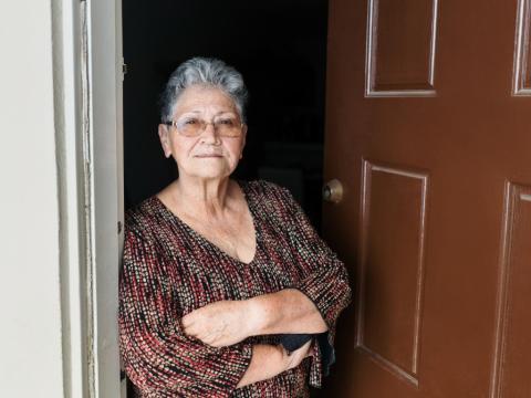 senior woman standing at door istock image