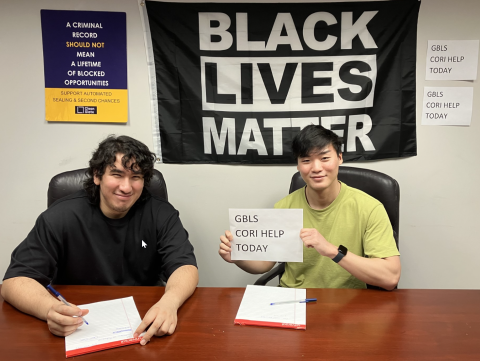 two gentlemen holding a sign that reads cori help today