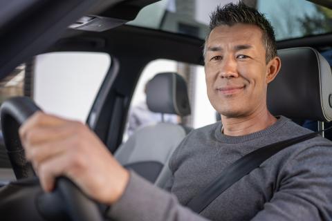 man smiling driving a car