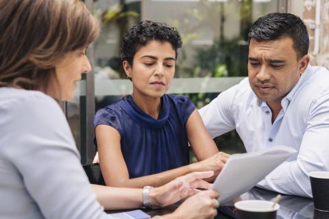 serious couple discussing tax paying paperwork