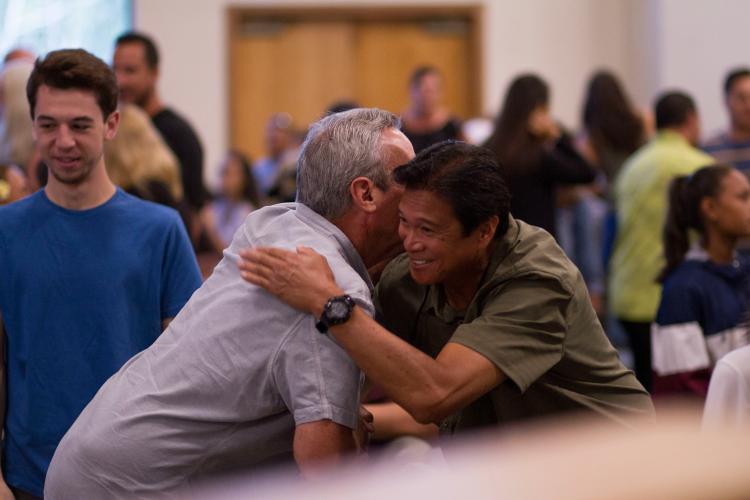 two men hugging in a crowded room